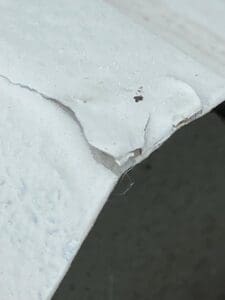 Image shows a new roof coating splitting and debonding from the roof surface during a roof coating inspection by roofsurveys.com