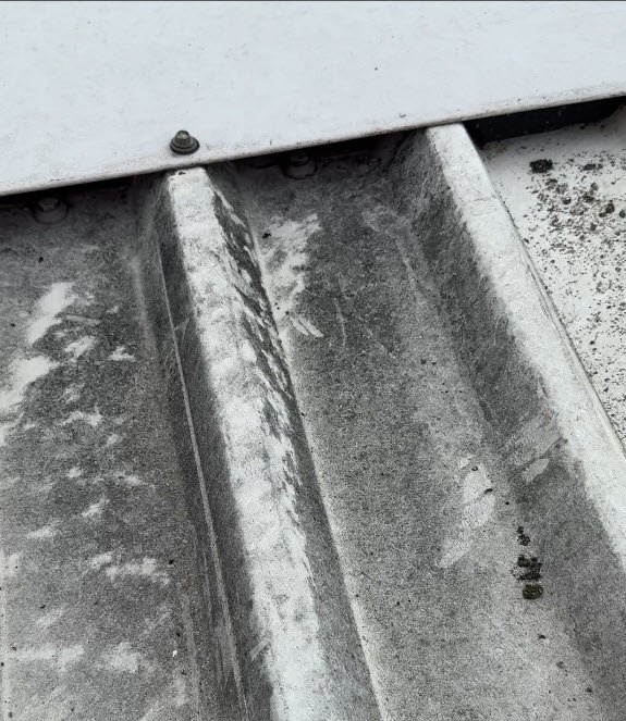 Image showing a black stained roof at the ridge detail, a commonly missed defect on metal roofs.